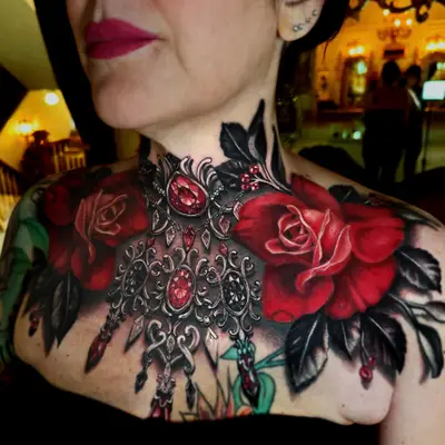 Intricate tattoo of roses and jewelry on woman's chest.