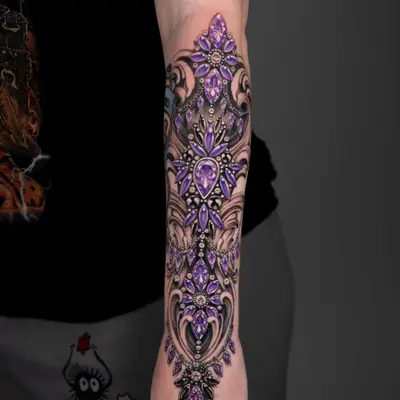 Intricate forearm tattoo featuring purple gem motifs and decorative elements.