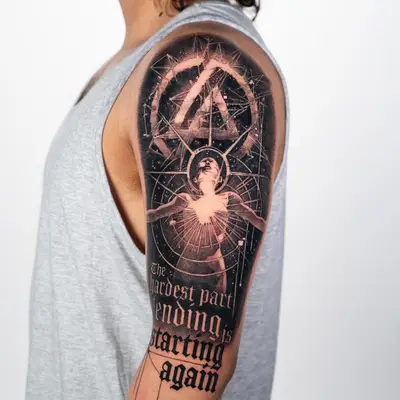 Tattoo on upper arm depicting geometric patterns and text.
