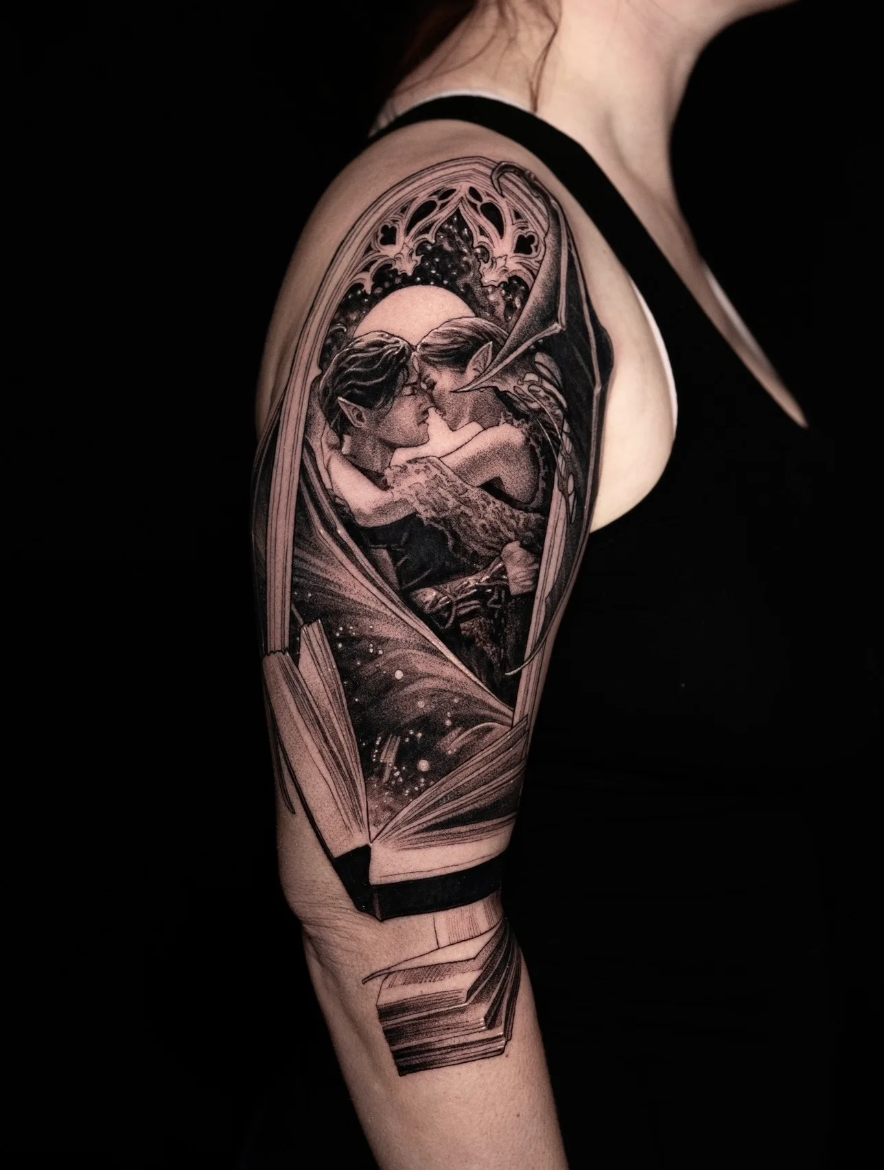 Tattoo of a romantic embrace within an open book on an arm.