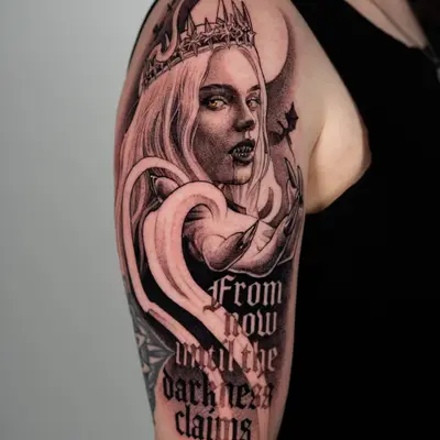 Black and grey tattoo on the upper arm of Manon Blackbeak from the Throne of Glass series in an iron crown, with gold eyes, iron-tipped nails, a full moon and bats behind her, and blackletter quote "From now until the darkness claims us"