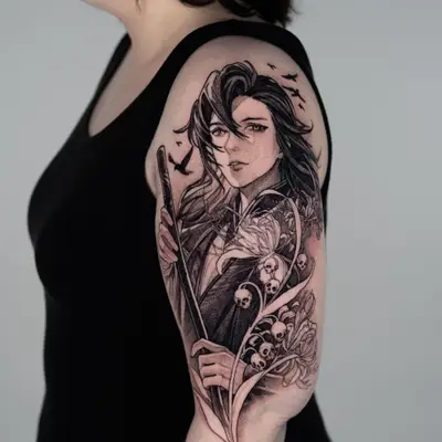 Black and grey tattoo on the outer bicep of Wei Wuxian holding a flute, surrounded by spider lilies with small skulls hanging from the stems and crows flying above.