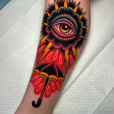 A vibrant tattoo featuring an eye above an umbrella with raindrops.