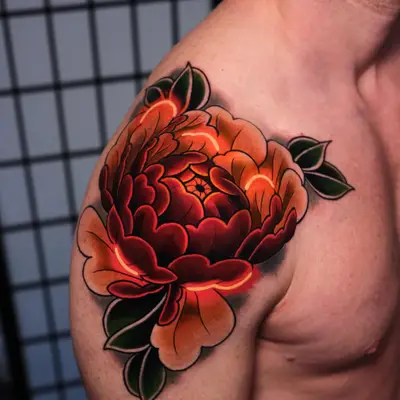 Vibrant floral tattoo on shoulder with shades of red and orange flowers.