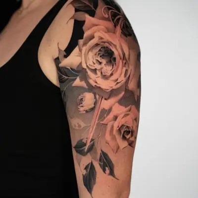 Black and grey floral tattoo on upper arm.