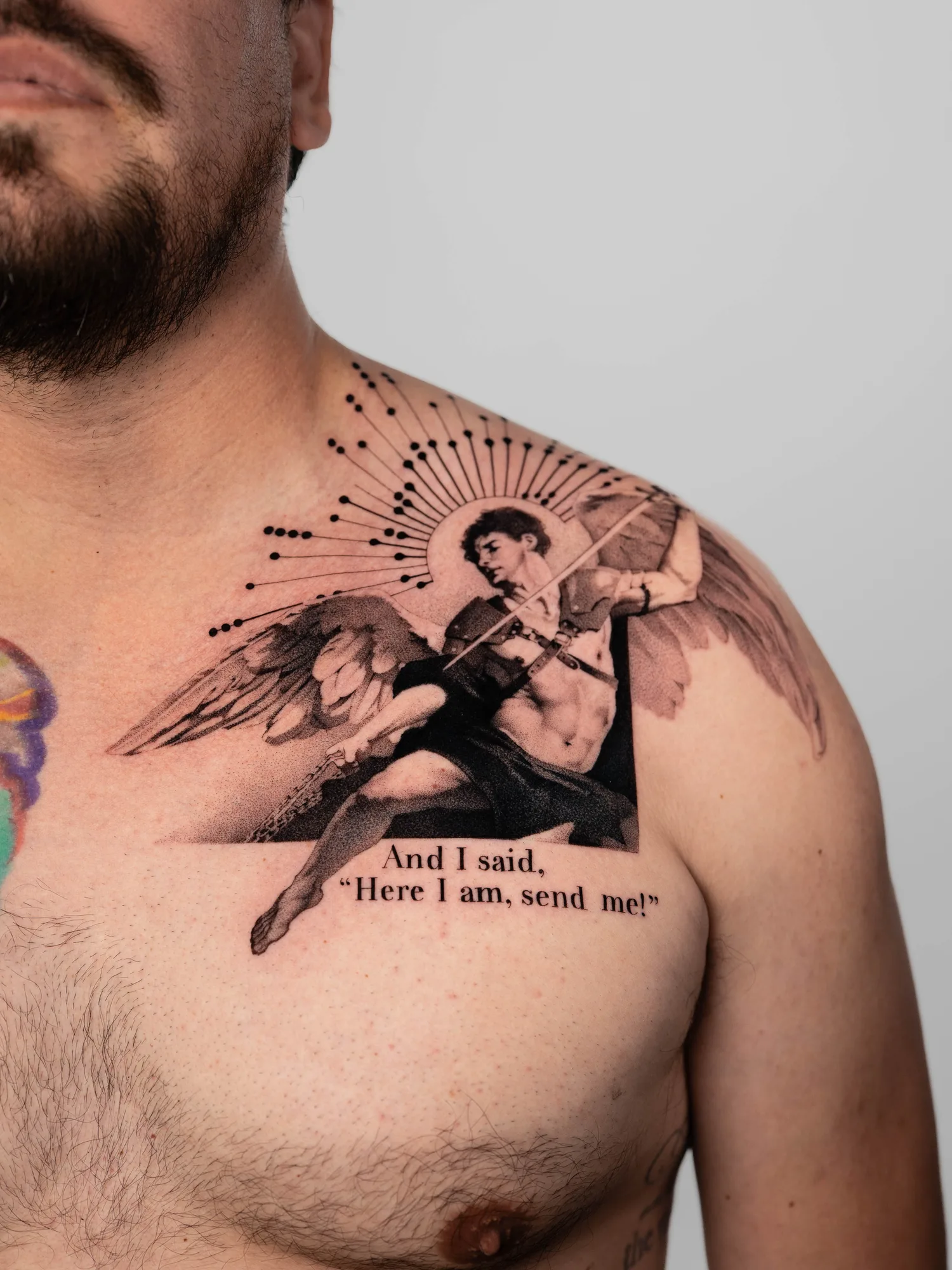 Tattoo of an angel with text 'Here I am, send me!' on man's chest.