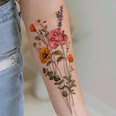 Tattoo of colorful flowers and a bee on a forearm.