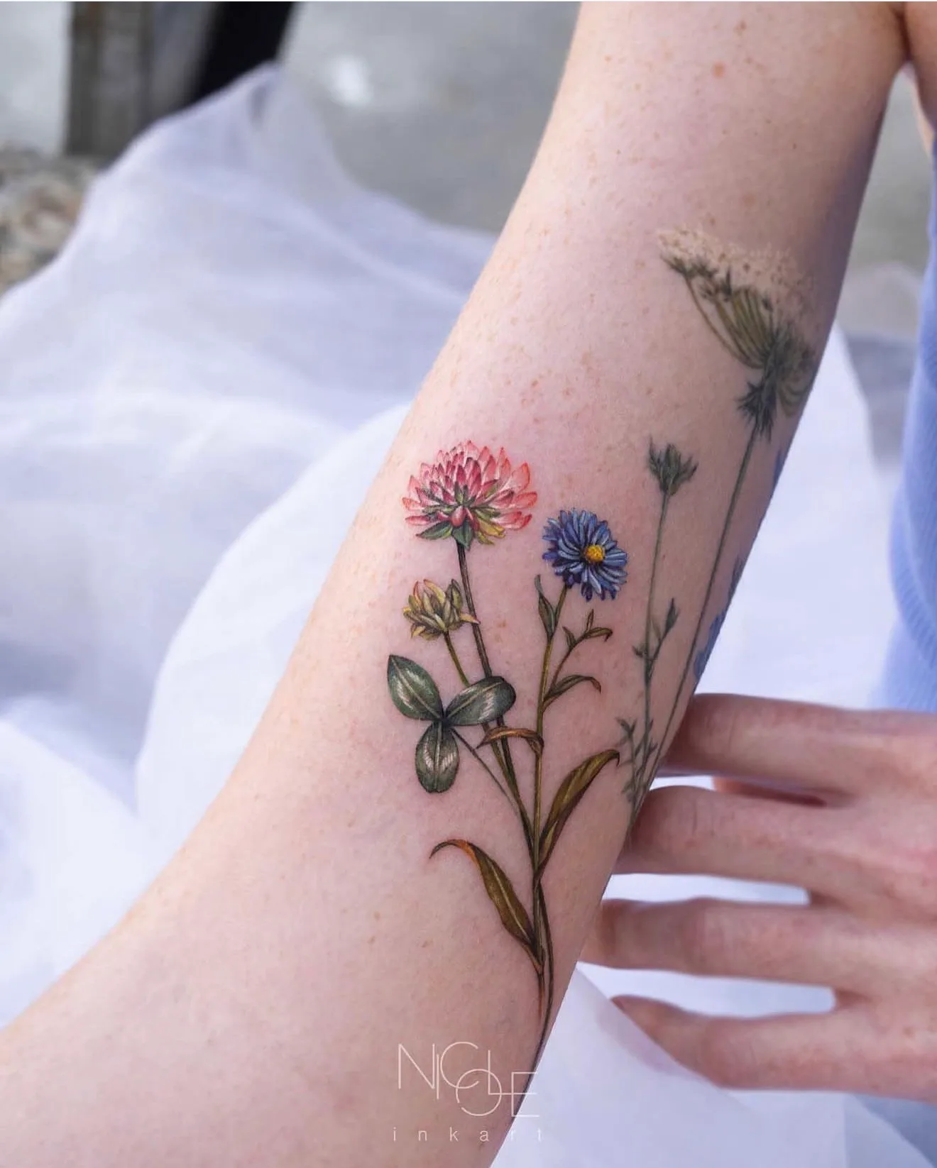 Tattoo of colorful wildflowers on forearm
