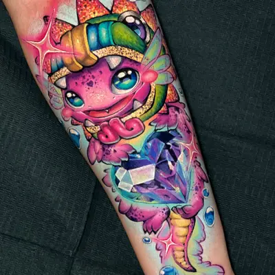 Color tattoo on a forearm of a cute pink baby dragon in a striped headband hugging a large faceted purple gem, with sparkles and blue water droplets on a pale blue glow