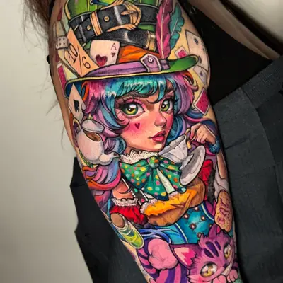 Color half sleeve tattoo on an upper arm of an anime-style girl as the Mad Hatter in a tall green top hat, sipping from a teacup, with playing cards behind her and the Cheshire Cat below