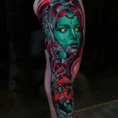 Colorful cybernetic woman tattoo on leg.
