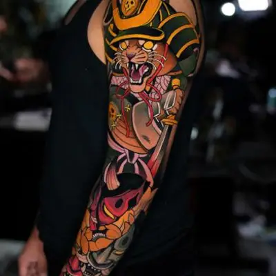 Japanese-style tattoo of warrior cat on upper arm.
