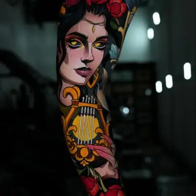 Tattoo of a woman with glowing eyes surrounded by flowers and musical elements.