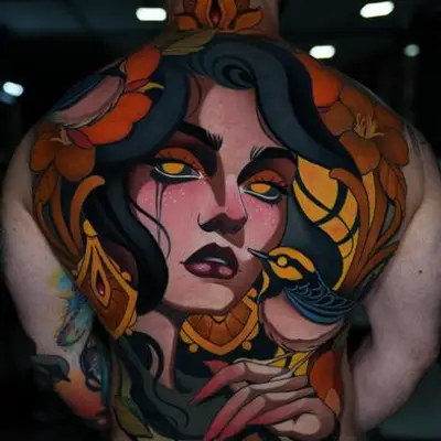 Tattoo of a woman's face with a bird and flowers on a person's back.
