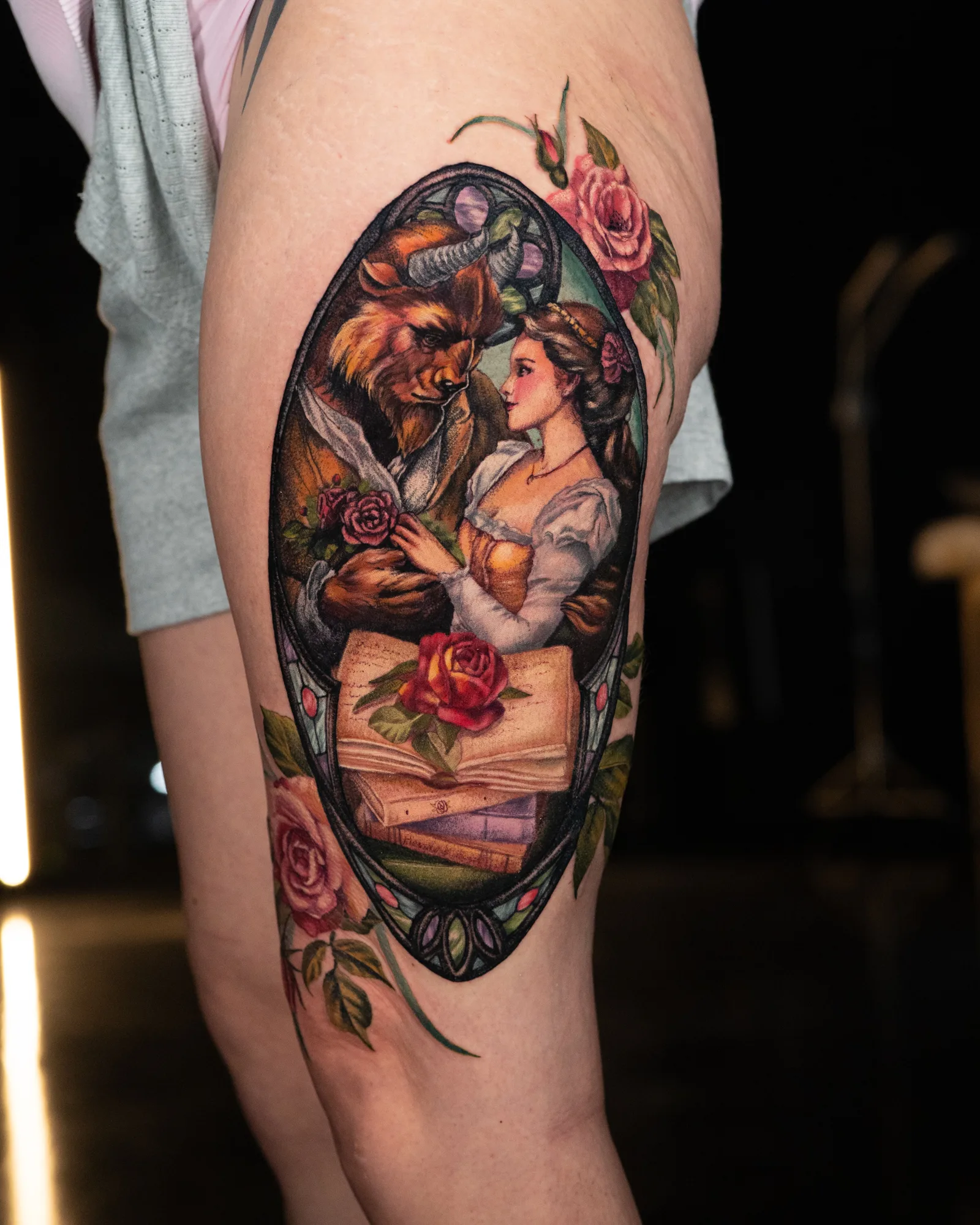 Tattoo of a Beauty and the Beast scene with roses.