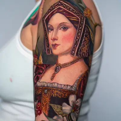 Portrait tattoo of a woman in Renaissance attire on upper arm.