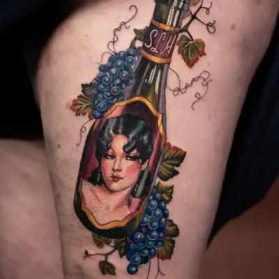 Tattoo of a woman in a wine bottle with grapes on thigh