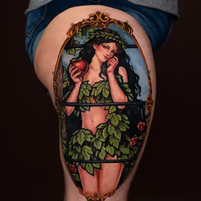Tattoo of a woman in foliage with an apple on thigh.