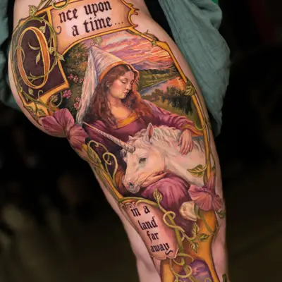 Color painterly tattoo of a maiden in a pointed hennin embracing a white unicorn, framed by an illuminated Once Upon A Time banner, on a leg panel.