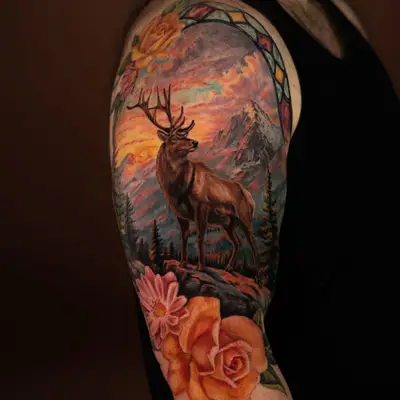 Color tattoo of an elk on a rocky outcrop against a sunset mountain range, under a stained glass arch, with roses and daisies below, on a half sleeve.