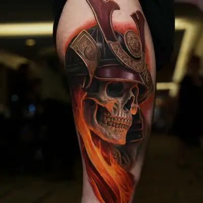 A striking skull with a samurai helmet and flames tattooed on the thigh.