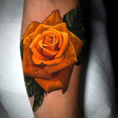 Tattoo of a yellow rose with water droplets in a reaslim style.