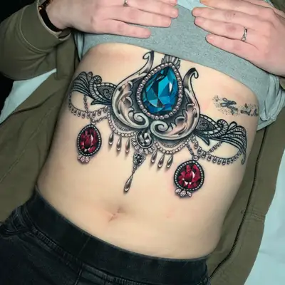 Tattoo of an ornamental sternum piece with realistic jewerly.