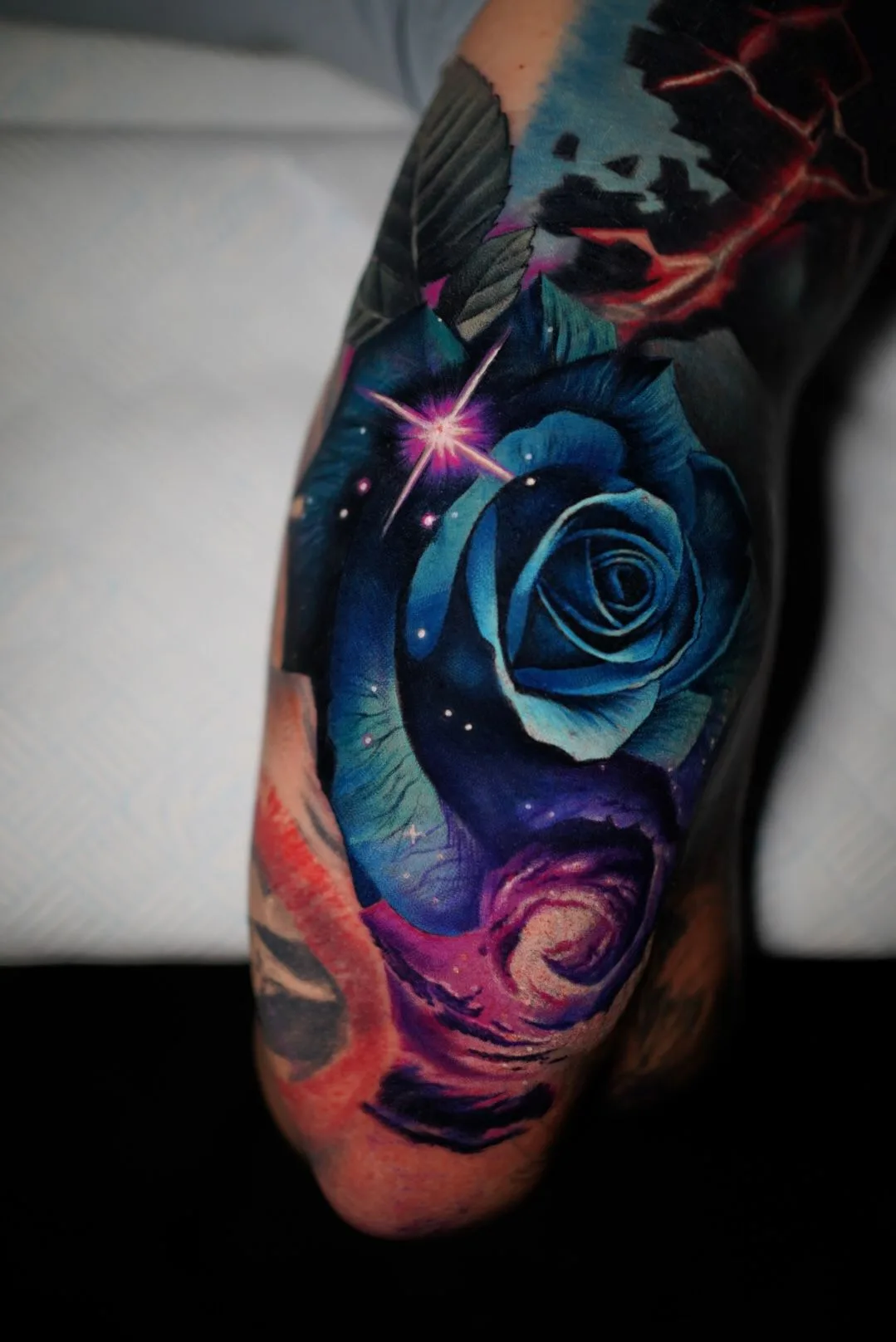 Tattoo of a blue rose in realism on the back of an arm.