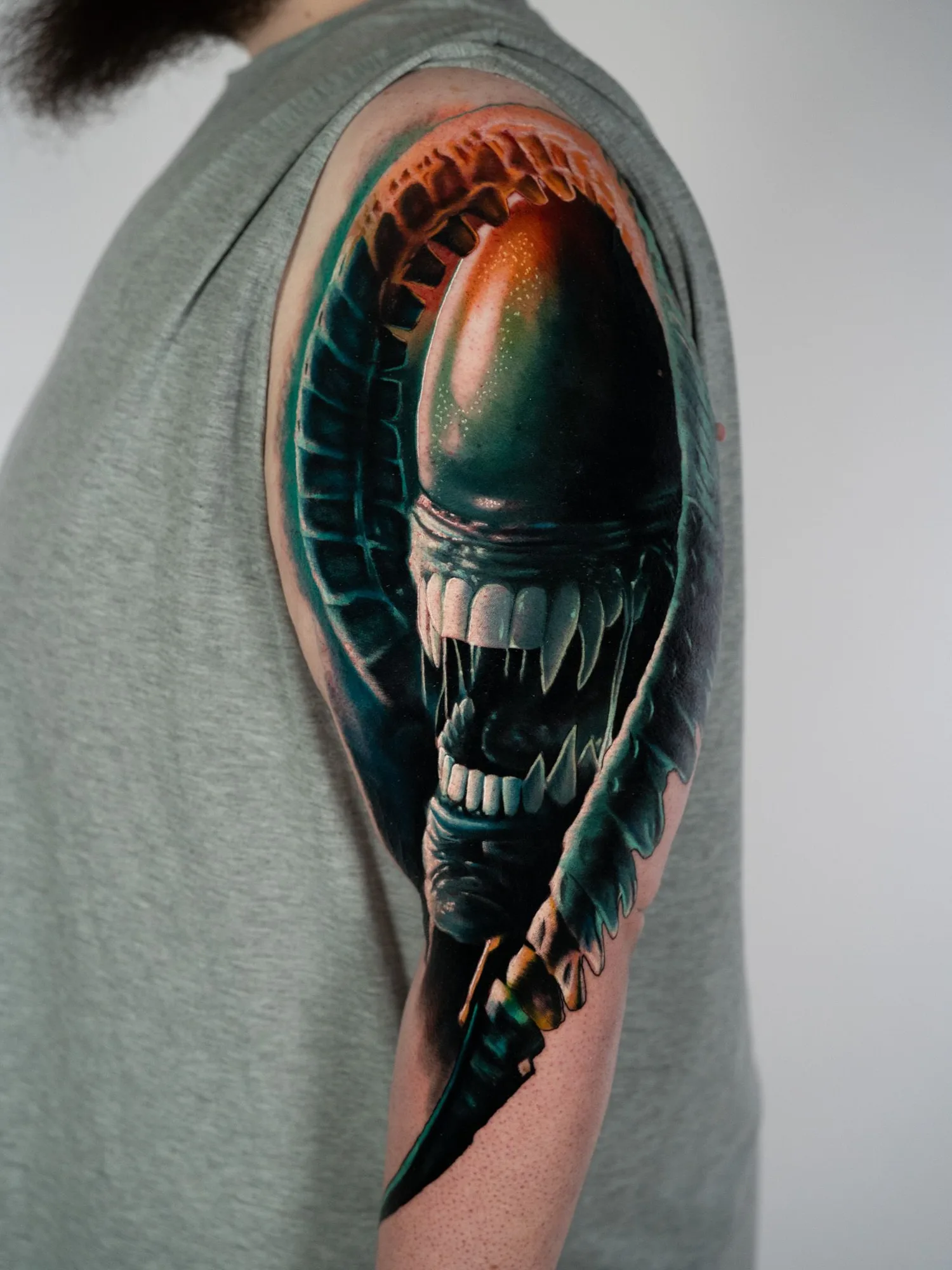 Detailed tattoo of a Xenomorph on the arm, showcasing a realistic style..