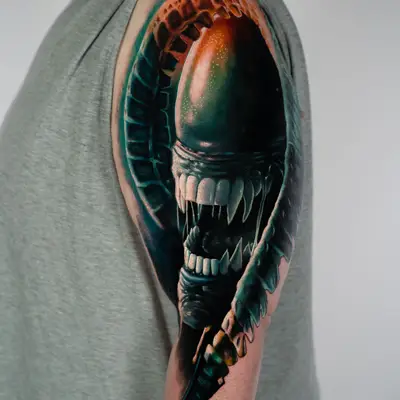 Detailed tattoo of a Xenomorph on the arm, showcasing a realistic style..