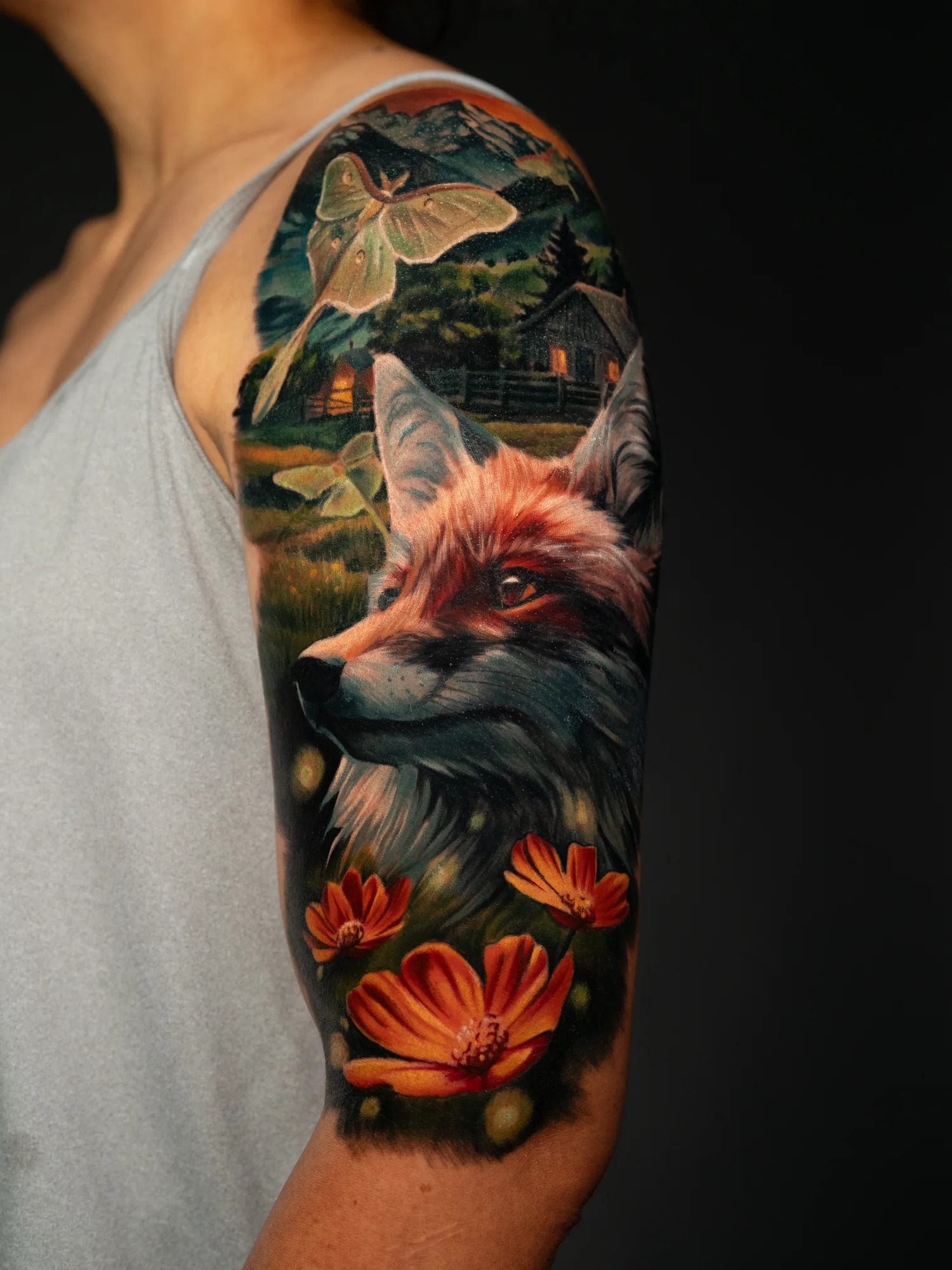 Tattoo of a realistic fox head with flowers on upper arm.