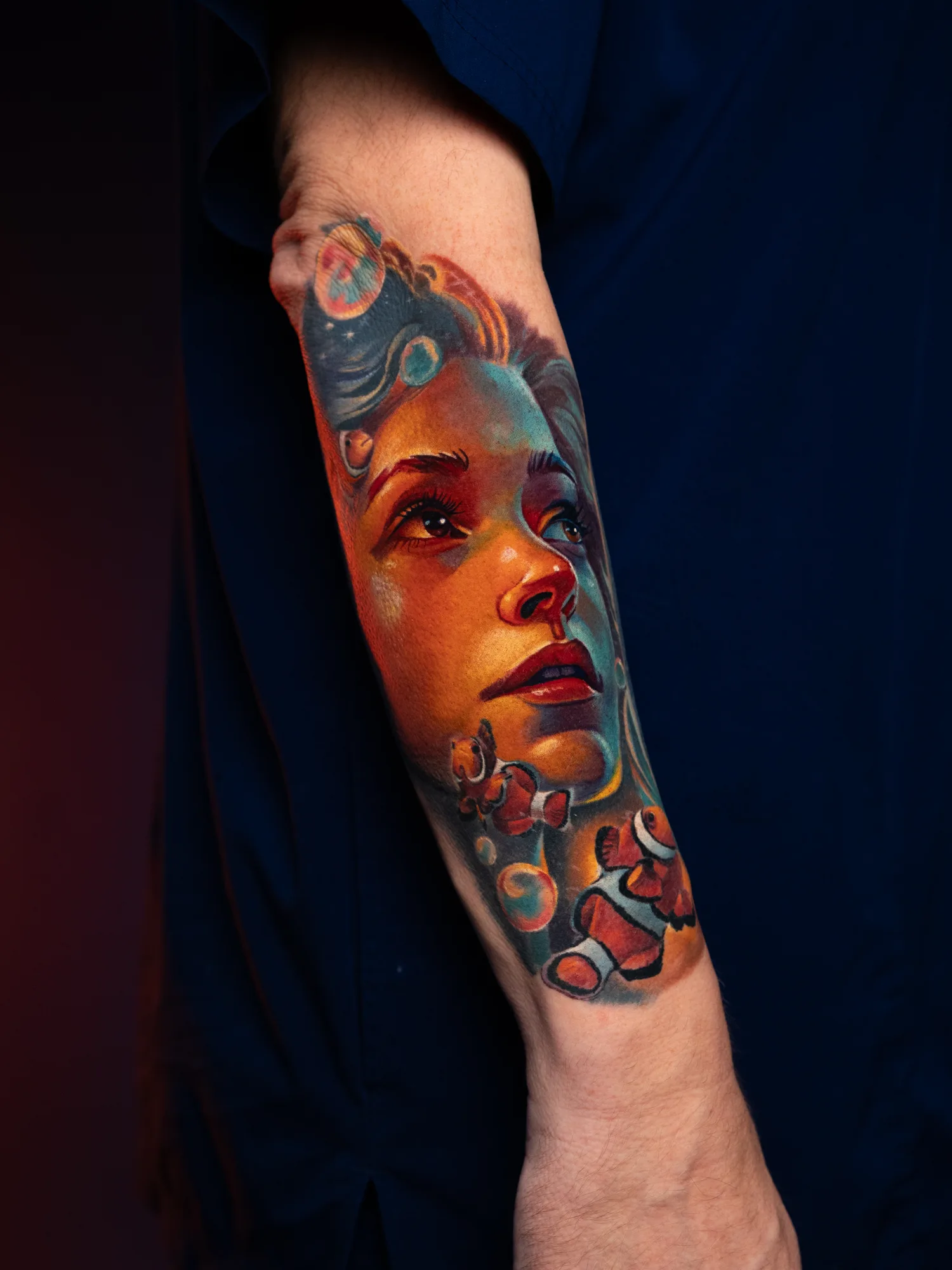 Colorful portrait tattoo with clownfish on forearm.