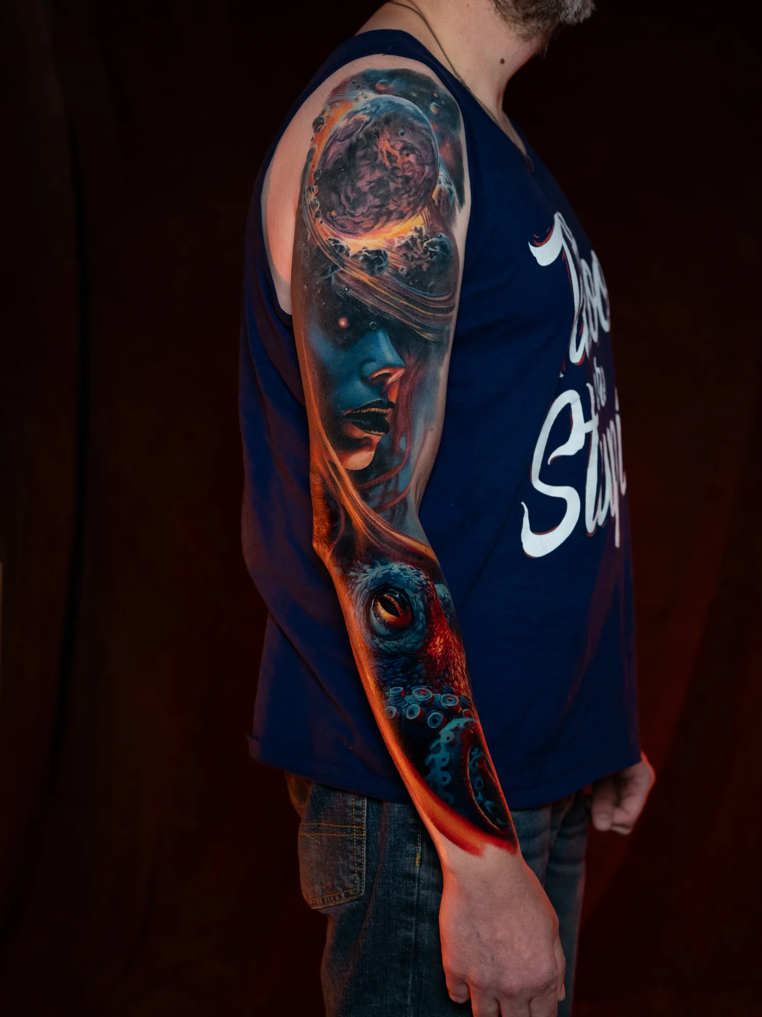 Colorful surrealism tattoo combining a woman’s face, an octopus, and a planet.