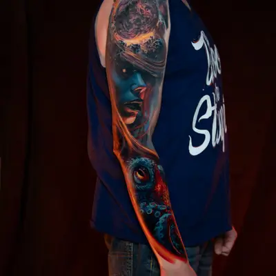 Colorful surrealism tattoo combining a woman’s face, an octopus, and a planet.