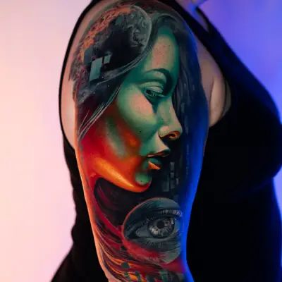 Colorful surrealistic tattoo of a woman's profile on an arm.