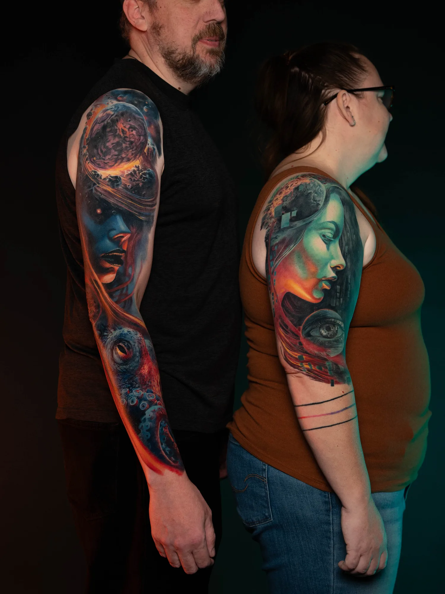 Colorful space-themed sleeve tattoos on two people's arms