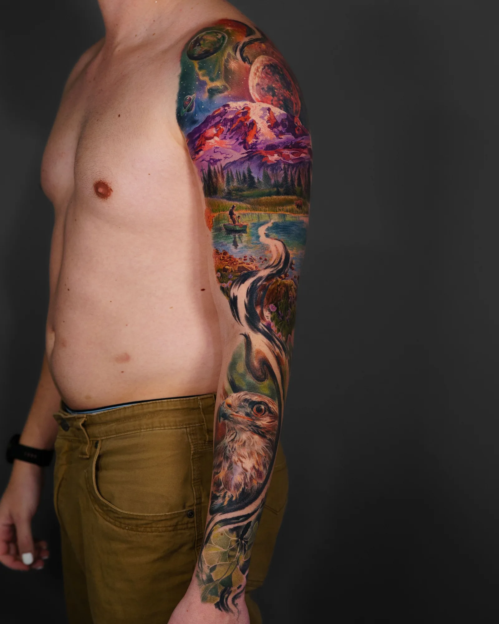 A colorful full sleeve tattoo featuring nature, wildlife, and space elements.