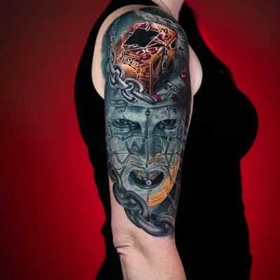 Half sleeve tattoo in color realism featuring Pinhead from Hellraiser and a puzzle box.