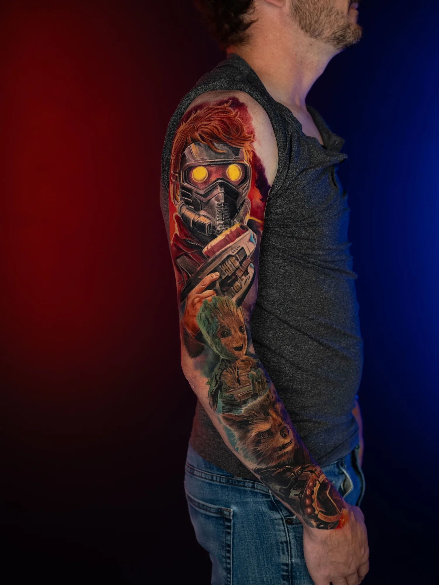 Full sleeve tattoo of Star-Lord, Groot, and Rocket from Guardians of the Galaxy in a color realism style.