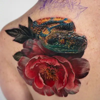 Colorful tattoo of a snake intertwined with a peony on the upper back in a realistic style..