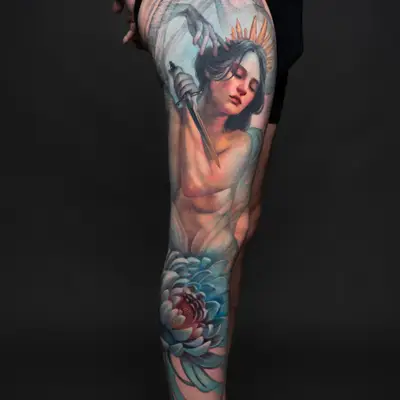 Leg tattoo of an angel with a sword and a large blue flower.