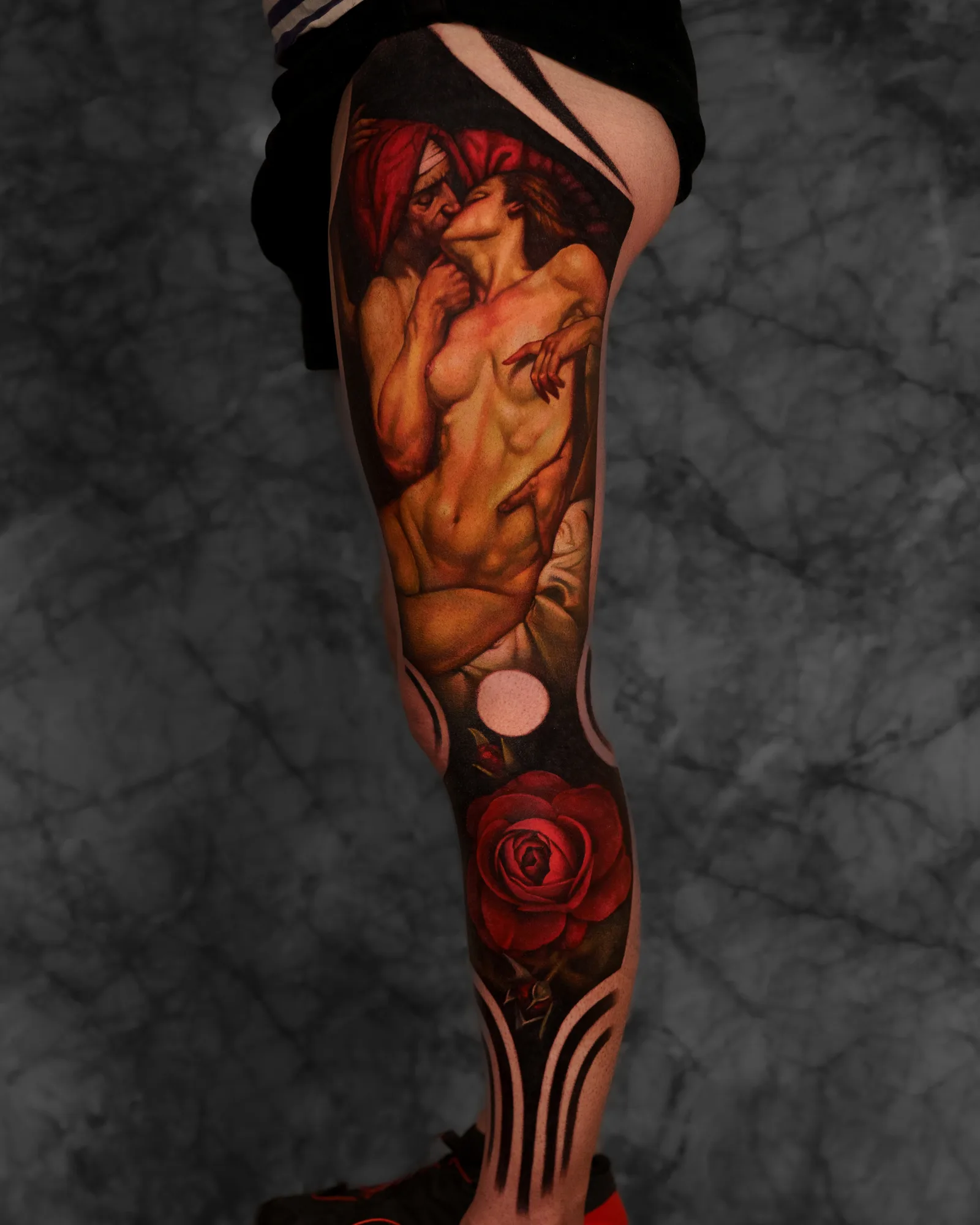 Leg tattoo featuring entwined couple and a red rose
