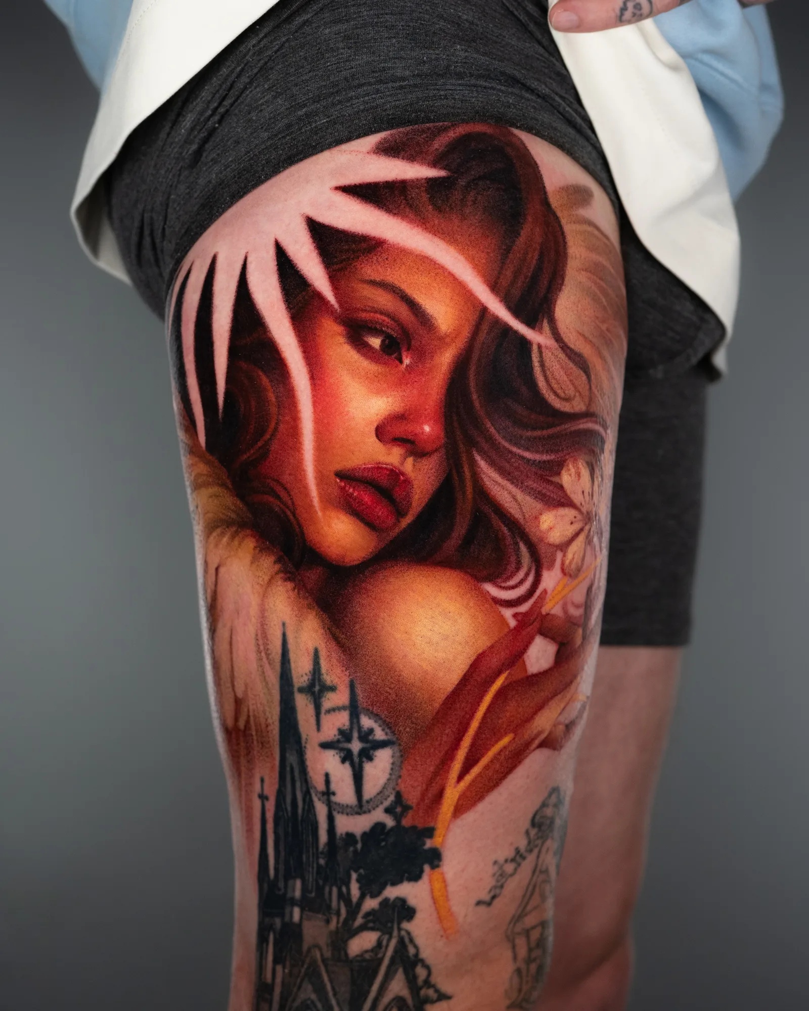 Tattoo of a lady holding a flower done in a painterly style on the thigh.