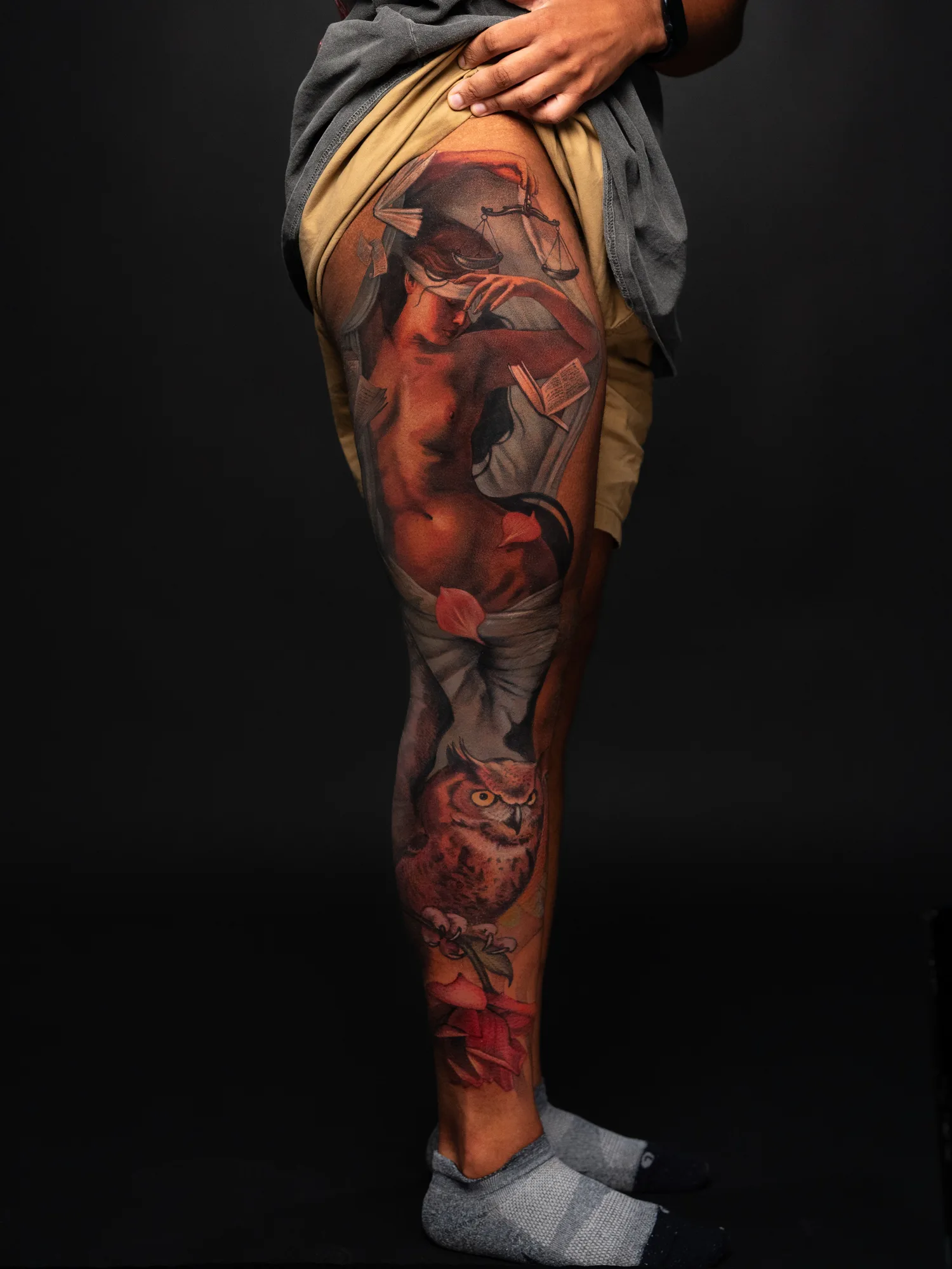 Leg sleeve tattoo of a woman and owl holding a rose.