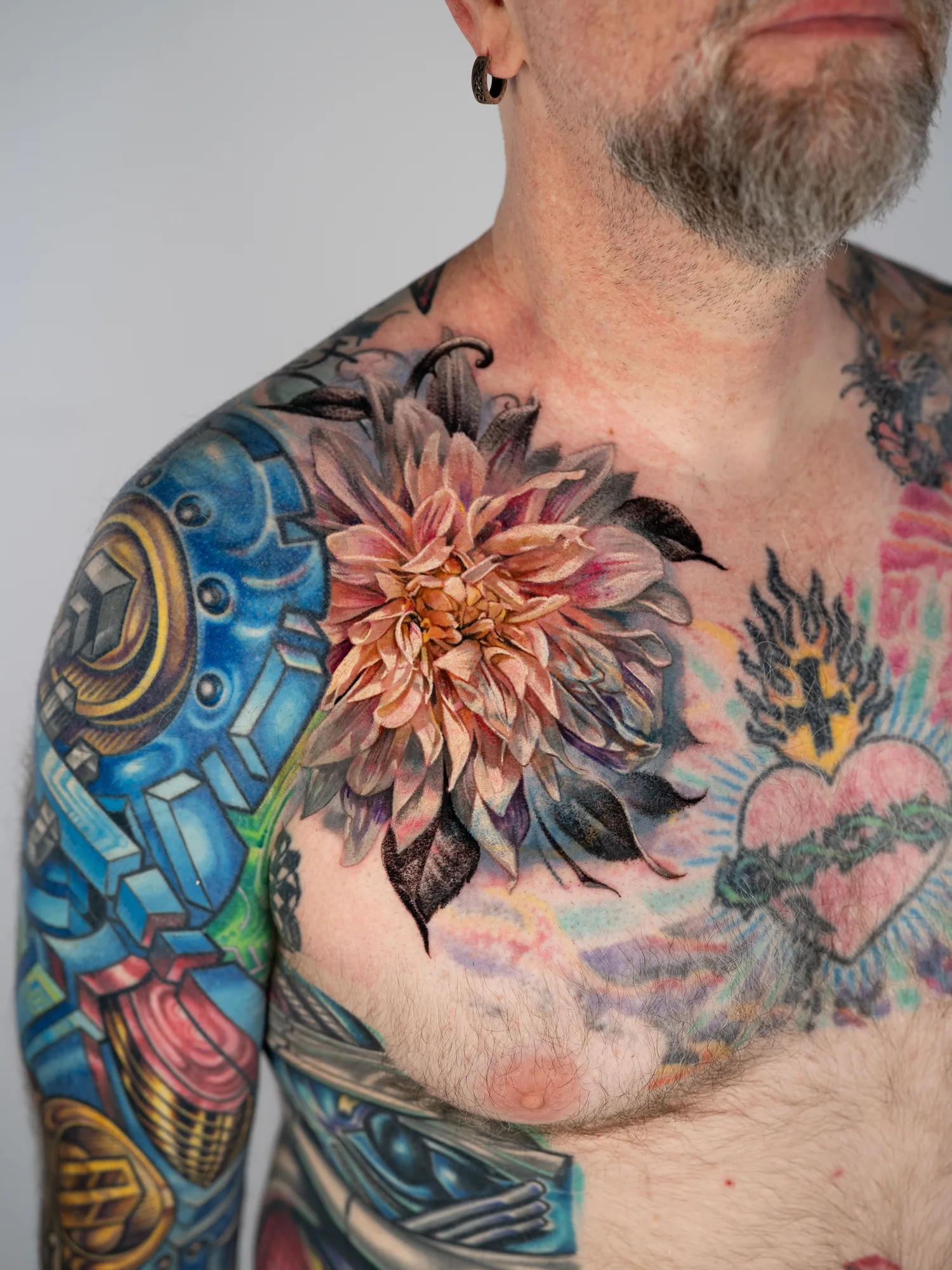 Colorful floral tattoo on shoulder with abstract designs on arm.