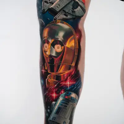 Full color Star Wars tattoo on a lower leg showing the Millennium Falcon, a C-3PO portrait and R2-D2 against a red and blue nebula.