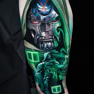 Tattoo of a metallic mask with green accents and a figure in a hooded cloak.
