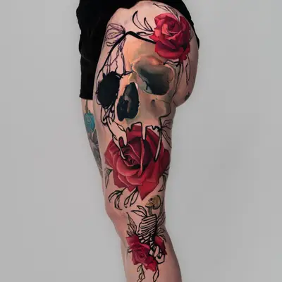 Tattoo of a skull with roses and a ribcage on thigh