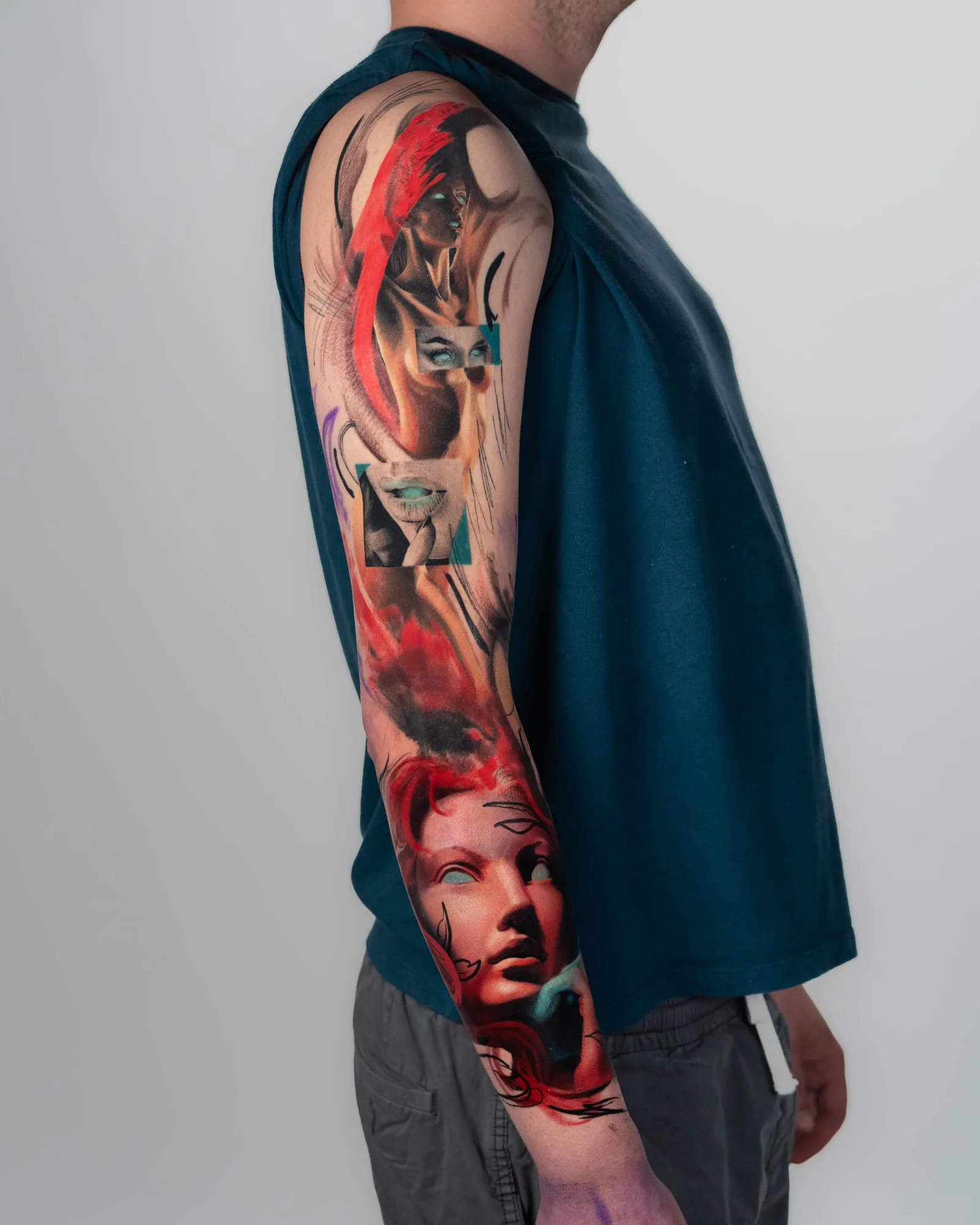 Colorful surrealist sleeve tattoo with faces and abstract elements.