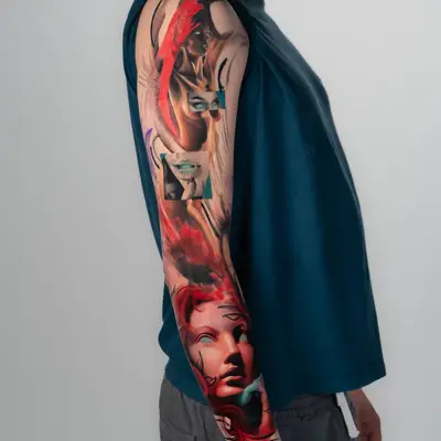 Colorful surrealist sleeve tattoo with faces and abstract elements.